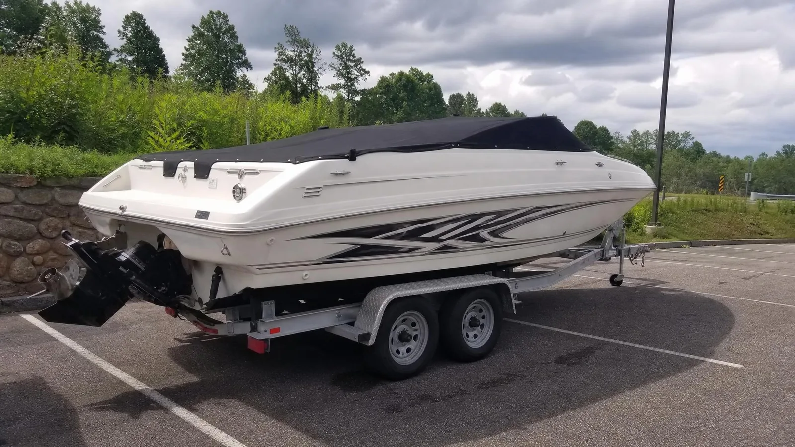 Source photo of a white speedboat on its trailer, 1 of 2, taken on a phone