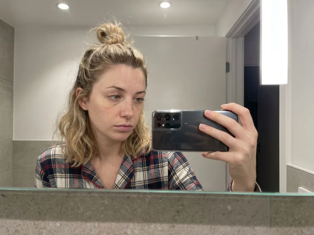 Source photo of a blonde woman with her hair in a bun, 1 of 3, taken on a phone