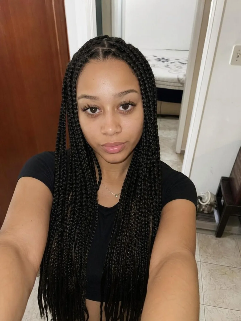 Source photo of a young woman with long braids, 1 of 1, taken on a phone