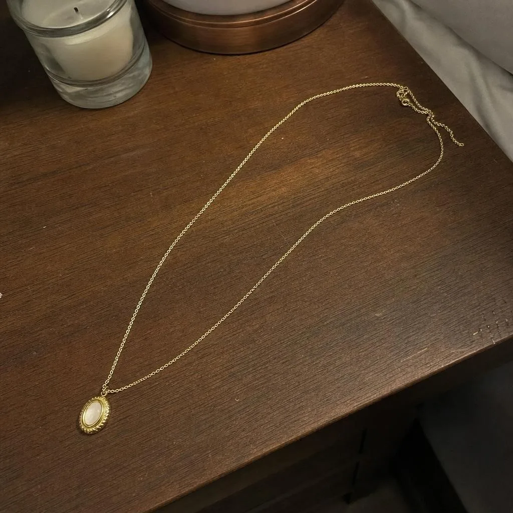 Source photo of a gold pendant necklace, 2 of 2, taken on a phone